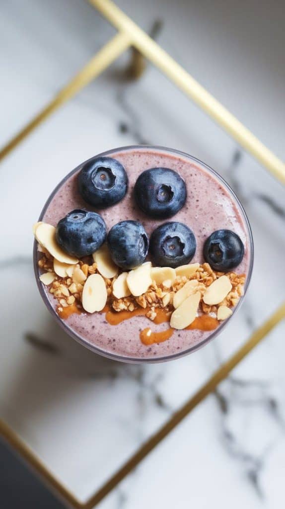 a Blueberry Almond Protein Smoothie topped with fresh blueberries, crunchy sliced almonds, and a drizzle of almond butter.