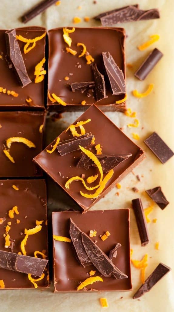 A super close-up shot of Chocolate Orange Fudge squares stacked on parchment paper